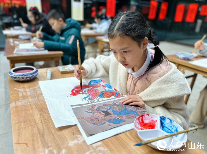 小学生正为雕版印刷孔府门神上色。人民网 乔姝摄.jpg